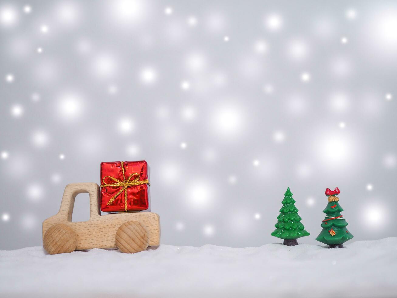 Wooden toy car, Gift box and Christmas tree with shiny light for Christmas and New Year holidays background, Winter season, falling snow, Copy space for Christmas and New Year holidays greeting card. photo