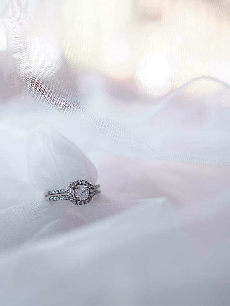 Diamond engagement wedding rings on bridal veil. Wedding accessories, Valentine's day and Wedding day concept. photo