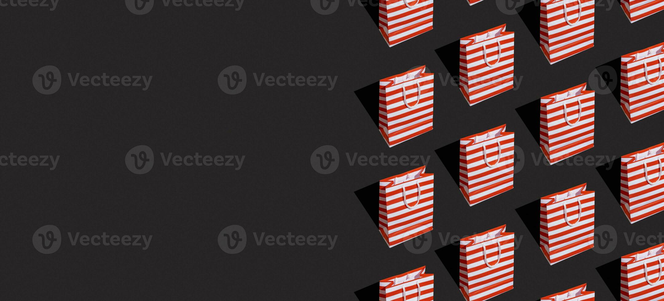 Pattern made from paper shopping bag on black background. Black friday sale, shopping concept. Banner with copy space. photo