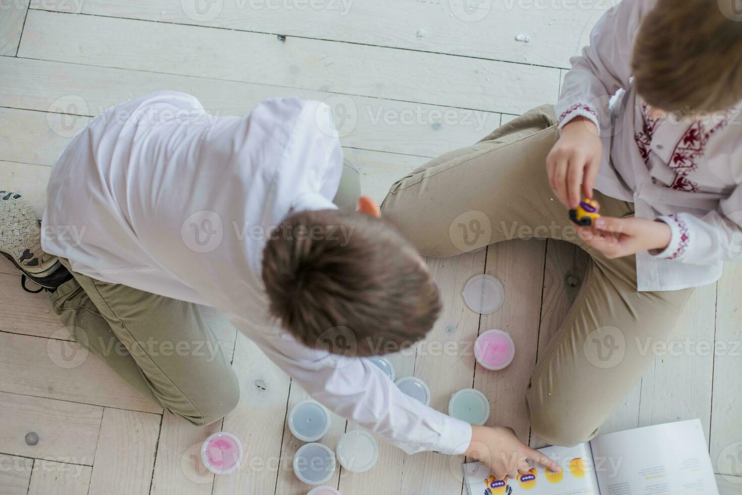 Two brothers play together. Children mold homemade from stiffening clay. Fun at home. Simple figures from plasticine do it yourself. photo