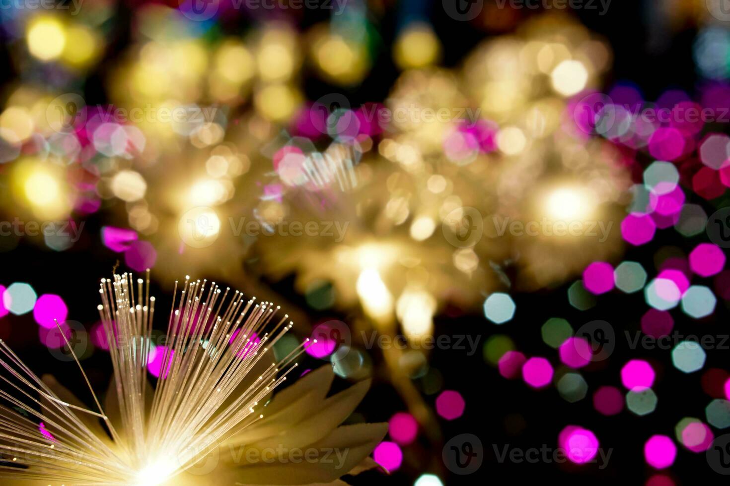 Closeup golden lighting flowers with light glowing up on colorful blurred and bokeh on night time background photo