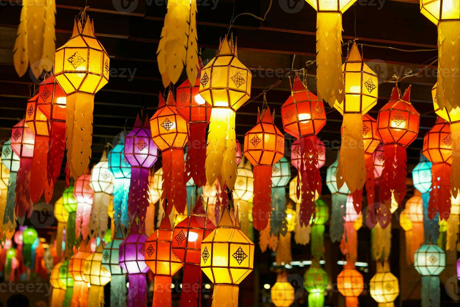 Closeup Colorful perspective view of Thai Lanna style lanterns to hanging on the ceiling and turn on light at night. photo