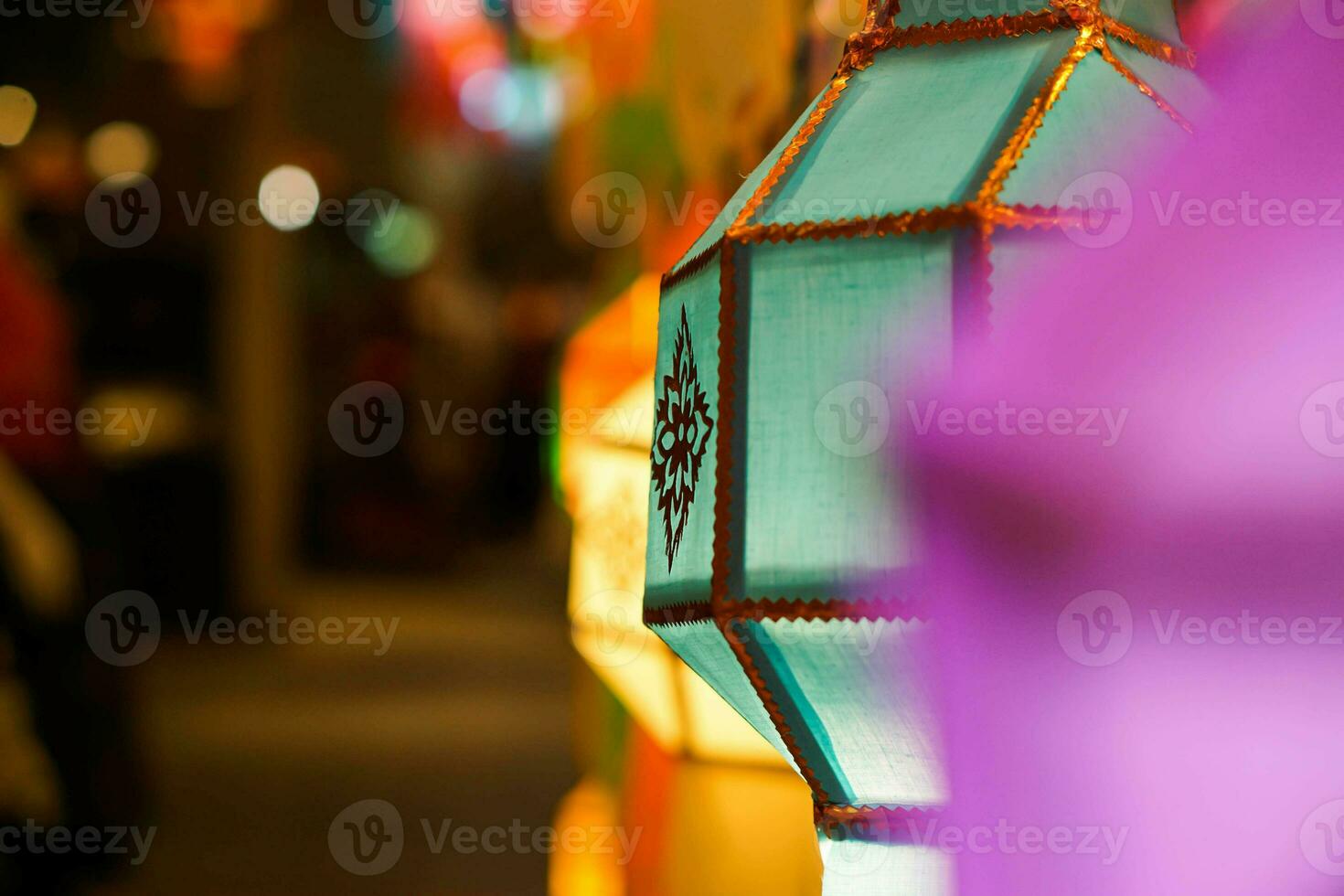 de cerca vistoso tailandés lanna estilo linternas a colgando y giro en ligero a noche. foto