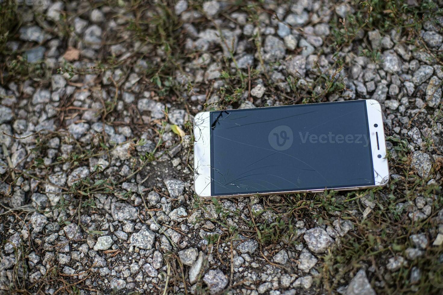 phone with broken screen. The fallen on the stones smartphone with cracked glass. photo
