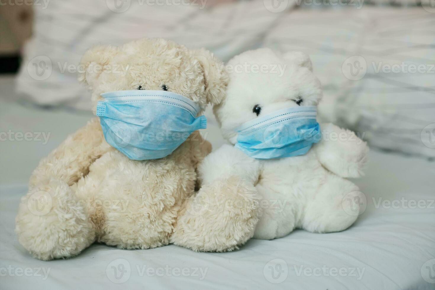 Two toy bears with medical masks on bed. Sicker disease in children. Coronovirus, quarantine, epidemic, pandemic, cold,illness. Medicine concept and health. photo