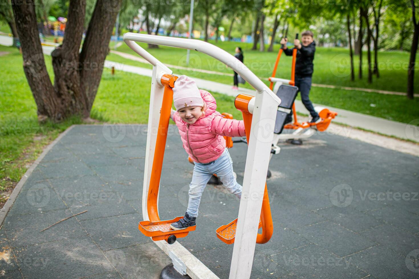 Family, brother and sister on Street simulators FEET BREEDING in a city park. Easy-to-use cardiovascular fitness equipment. Prevention of cardiovascular diseases. photo