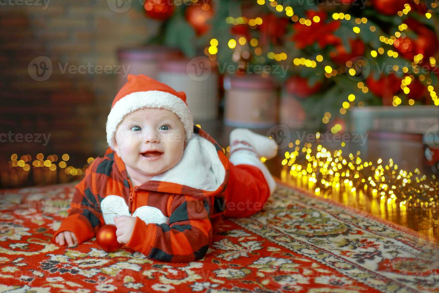 Little six month old baby dressed as Santa Claus. Background for christmas card. The child looks down at the place for inscription. photo