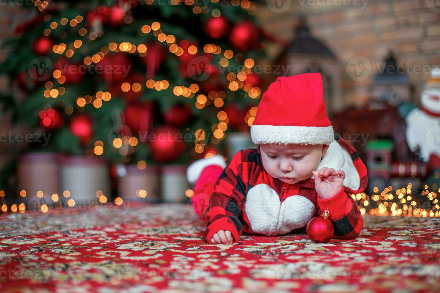 Little six month old baby dressed as Santa Claus. Background for christmas card. The child looks down at the place for inscription. photo