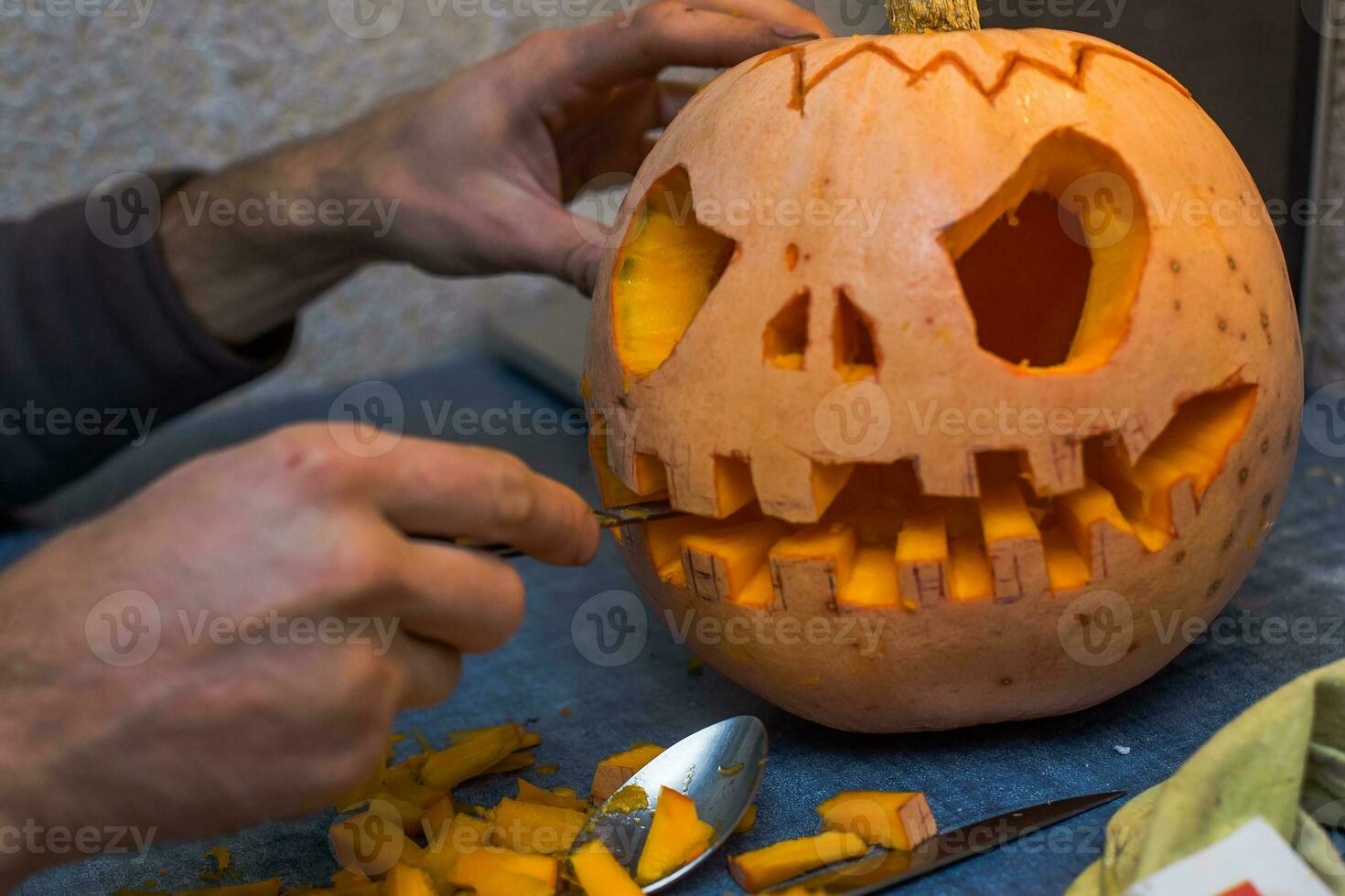 family fun activity. arved pumpkins into jack-o-lanterns for halloween. Carving big orange pumpkins for Halloween in late Autumn. photo