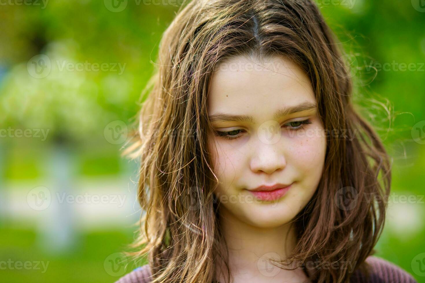 Portrait of a beautiful girl with dark blond hair in a city park in the spring photo