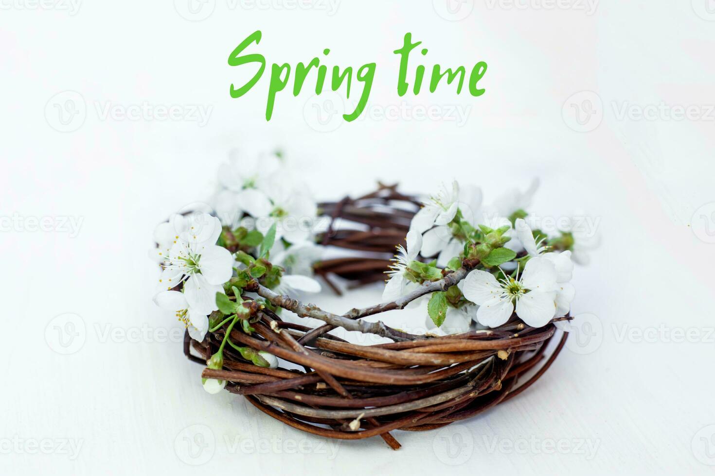 Text Spring Time. wreath of branches and cherry blossom on white background. Spring background. photo