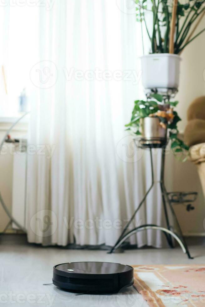 Robot vacuum cleaner drives on carpet. Overcoming obstacles with robot vacuum cleaner. ideal cleaning of house with modern wireless appliances. concept of smart home photo