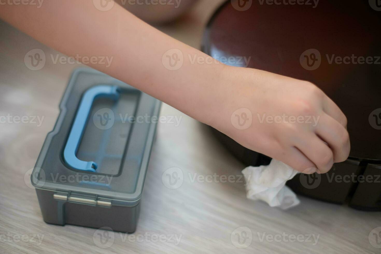 cuidando para limpieza robot vacío limpiador. mano con servilleta limpiando contaminación en vacío limpiador. agua envase para mojado casa limpieza. robot vacío limpiador servicio. inteligente hogar concepto foto