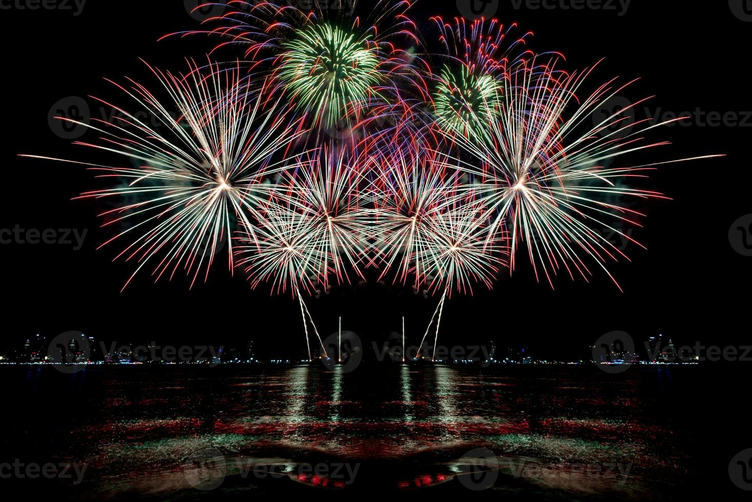 Amazing beautiful colorful fireworks display on celebration night, showing on the sea beach with multi color of reflection on water photo