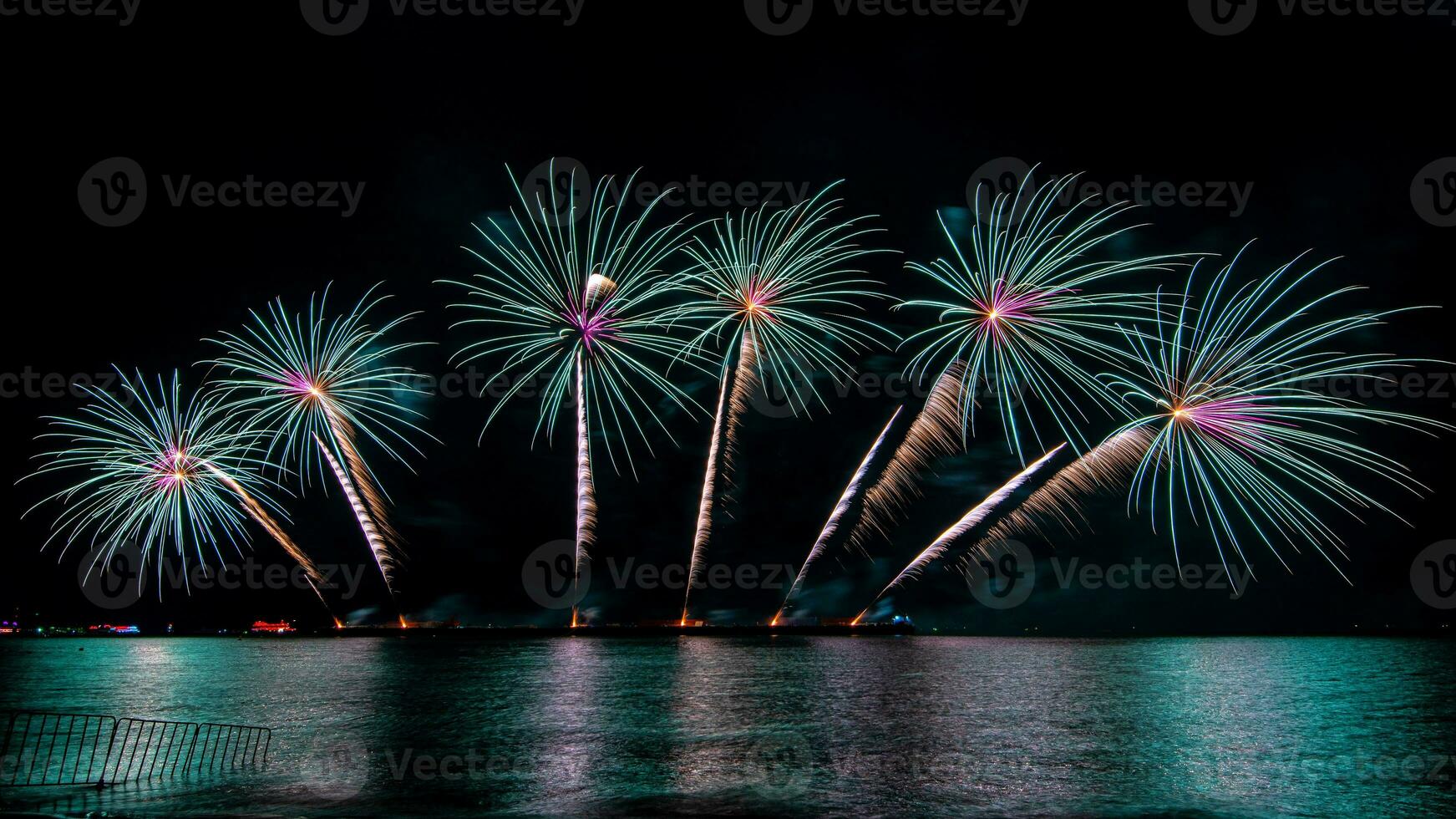 Amazing beautiful colorful fireworks display on celebration night, showing on the sea beach with multi color of reflection on water photo