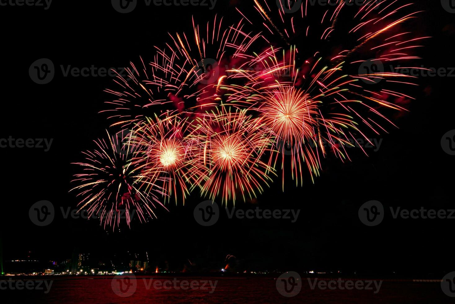 Amazing beautiful colorful fireworks display on celebration night, showing on the sea beach with multi color of reflection on water photo