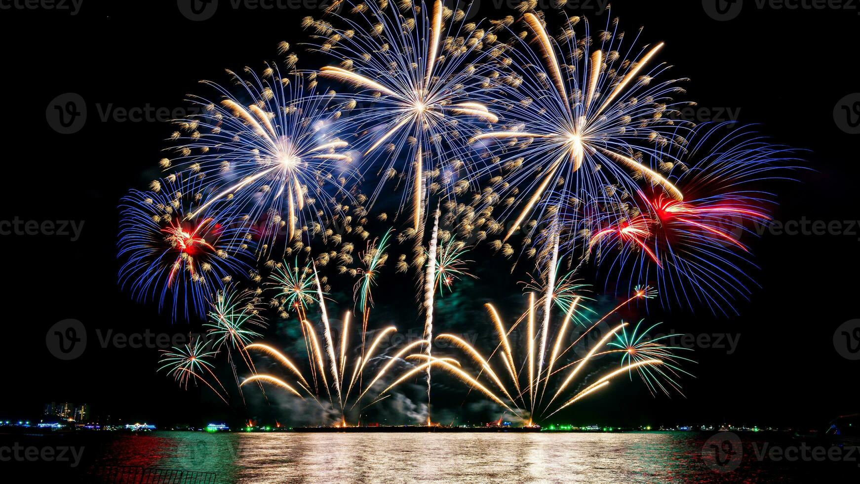 Amazing beautiful colorful fireworks display on celebration night, showing on the sea beach with multi color of reflection on water photo