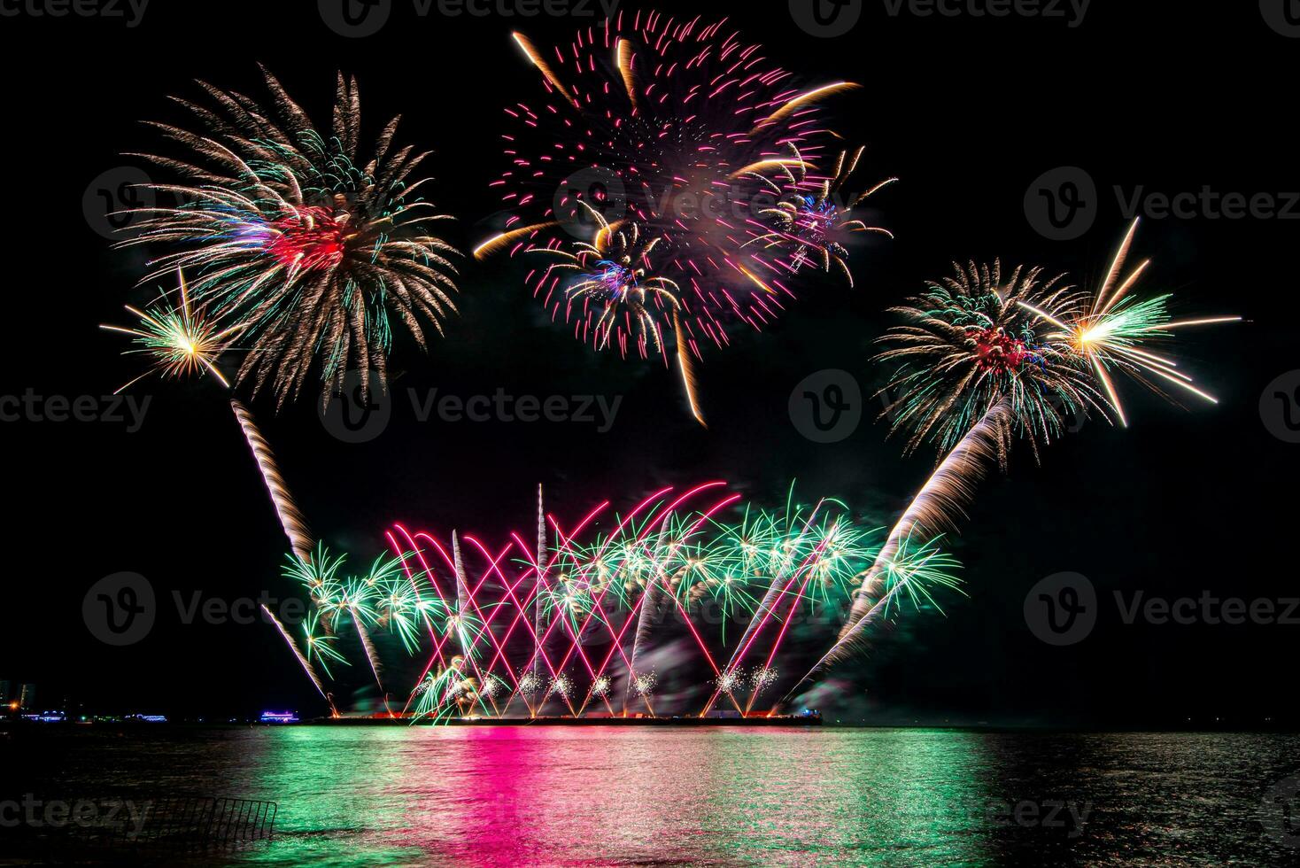 Amazing beautiful colorful fireworks display on celebration night, showing on the sea beach with multi color of reflection on water photo