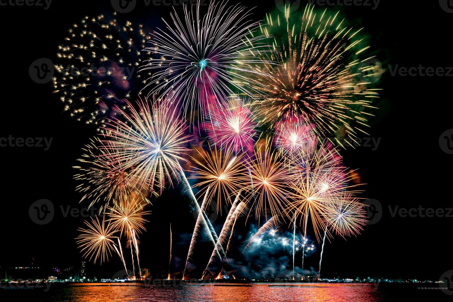 Amazing beautiful colorful fireworks display on celebration night, showing on the sea beach with multi color of reflection on water photo