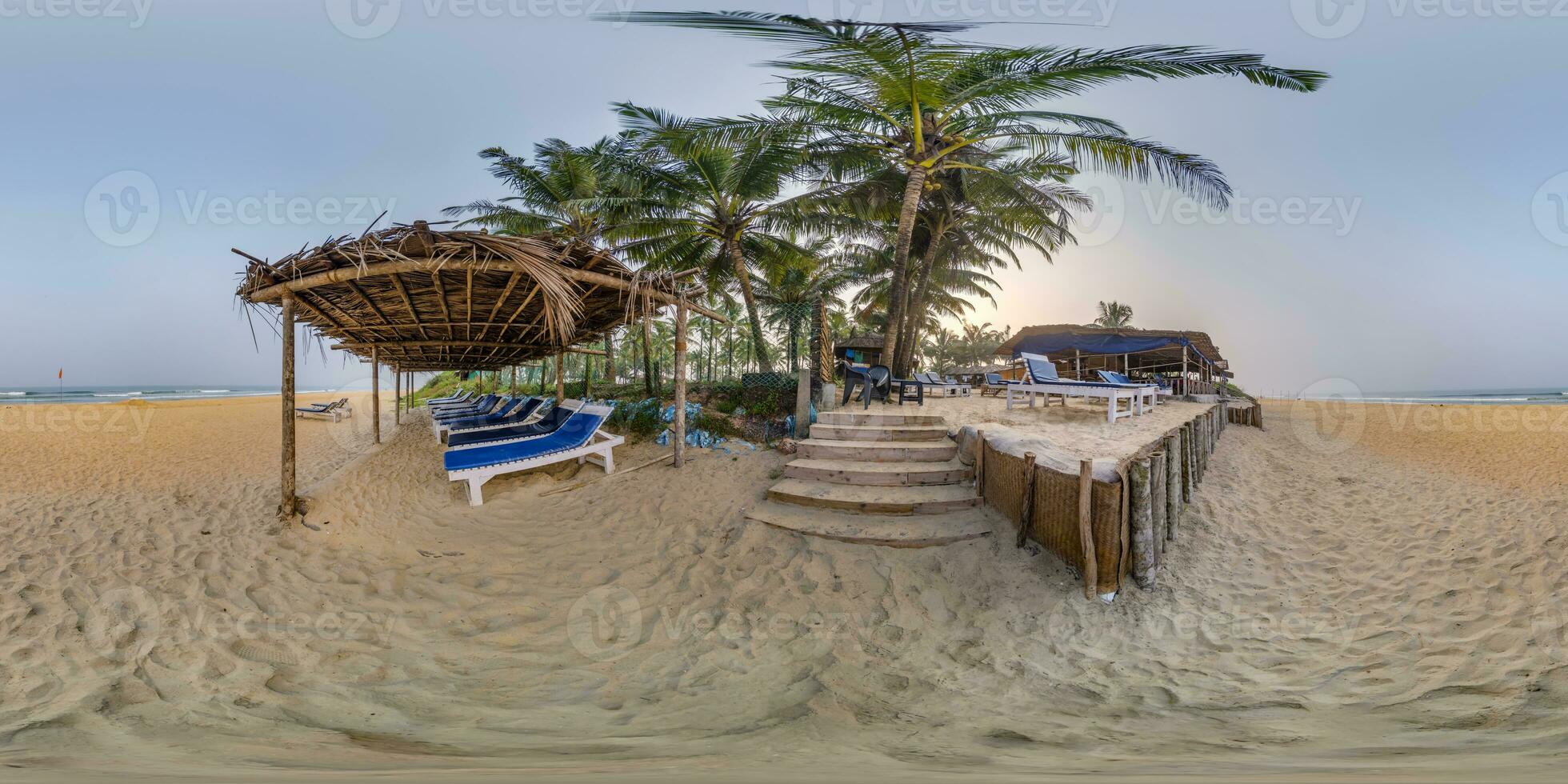 360 hdri panorama with coconut trees on ocean coast near tropical shack or open cafe on beach with sunbeds in equirectangular spherical seamless projection photo