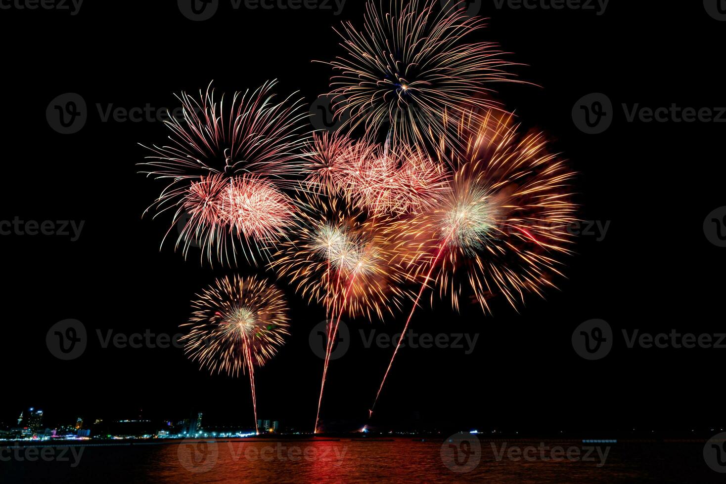 Amazing beautiful colorful fireworks display on celebration night, showing on the sea beach with multi color of reflection on water photo