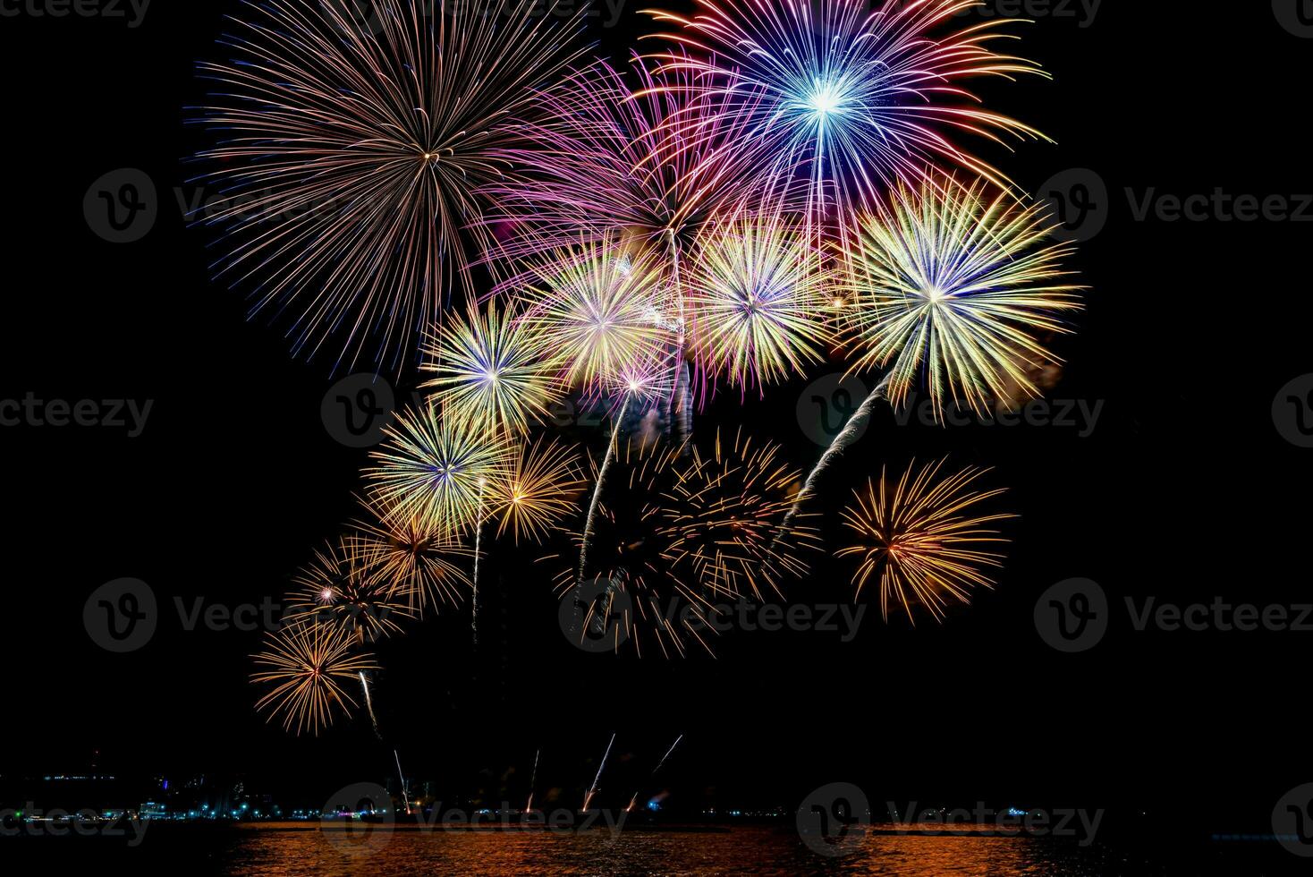 Amazing beautiful colorful fireworks display on celebration night, showing on the sea beach with multi color of reflection on water photo