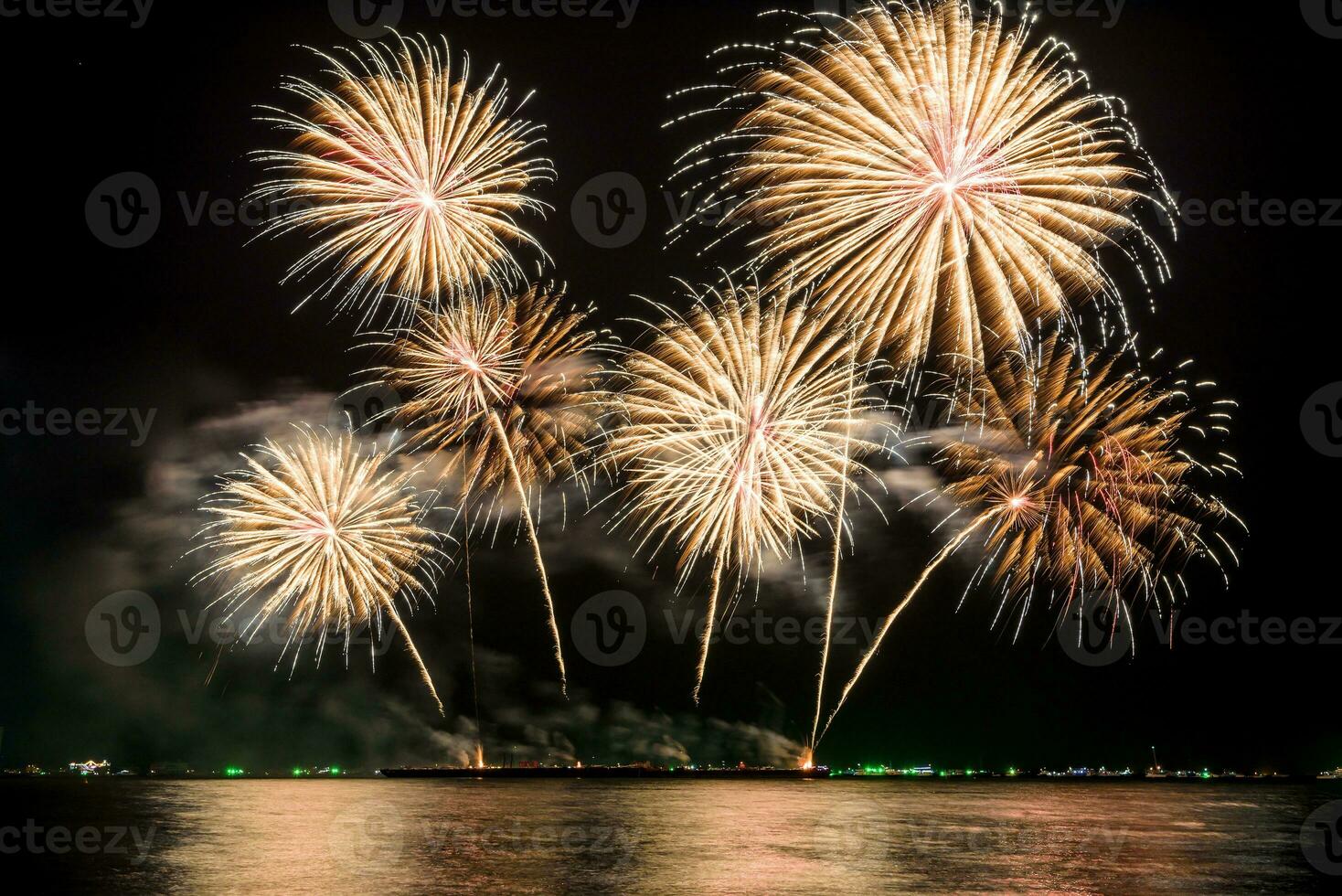 Amazing beautiful colorful fireworks display on celebration night, showing on the sea beach with multi color of reflection on water photo