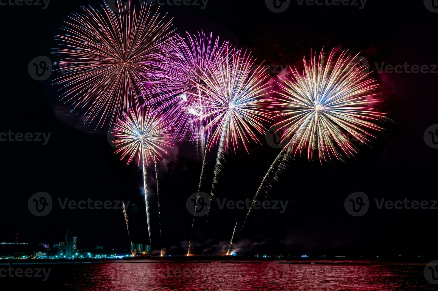 Amazing beautiful colorful fireworks display on celebration night, showing on the sea beach with multi color of reflection on water photo