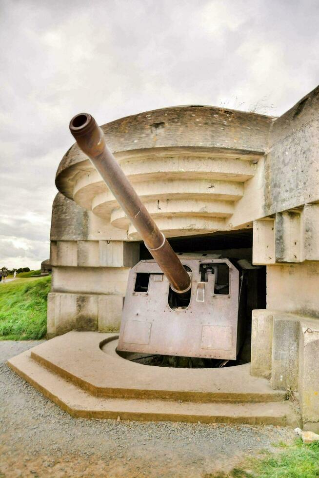 a large cannon is sitting in a concrete bunker photo