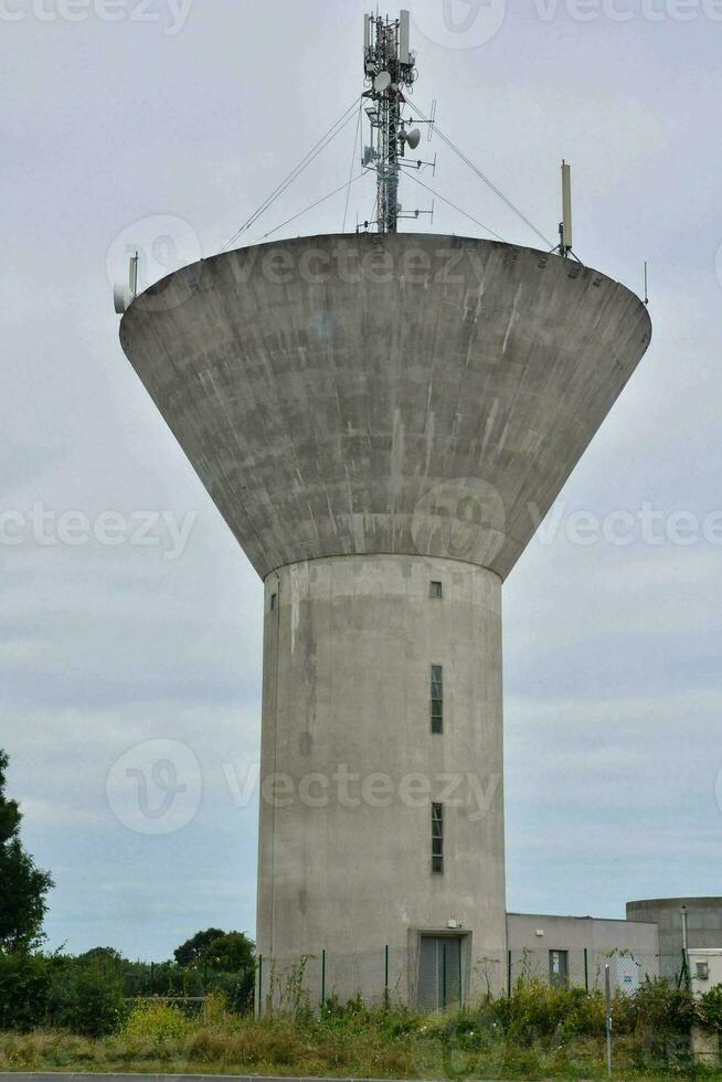 un hormigón agua torre con un grande antena en parte superior foto