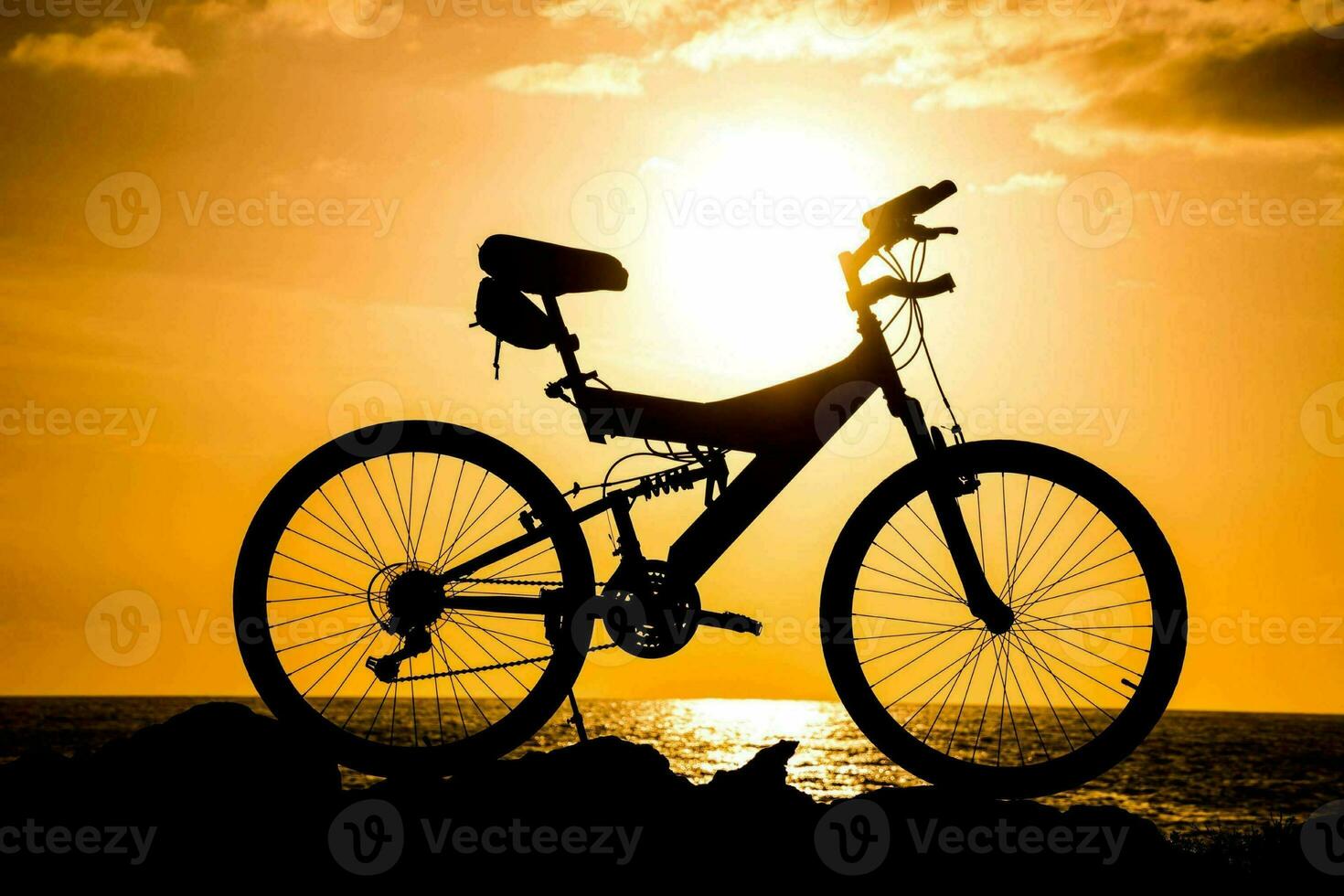 a bicycle is silhouetted against the sun at sunset photo