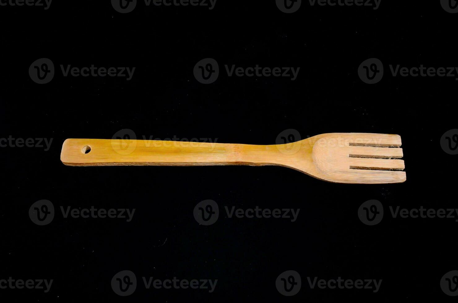 a wooden fork on a black background photo