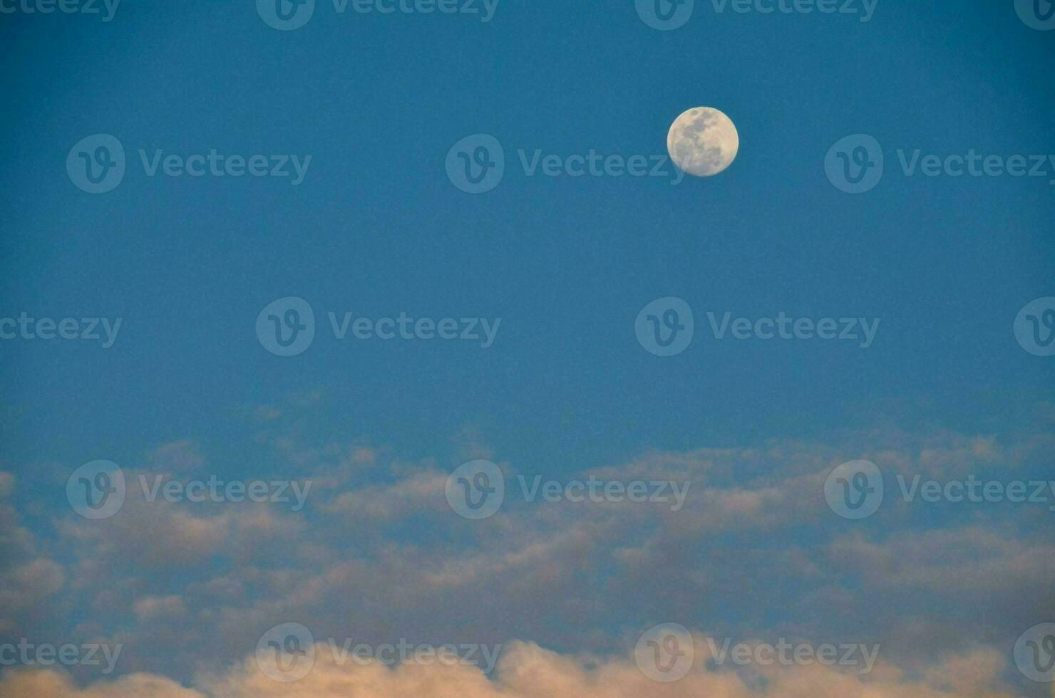 the moon is seen in the blue sky with clouds photo