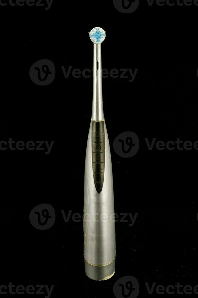 a silver and blue toothbrush on a black background photo