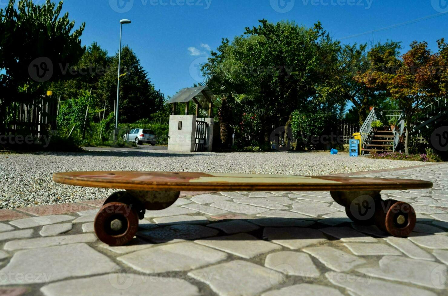 a skateboard on a stone road with trees in the background photo