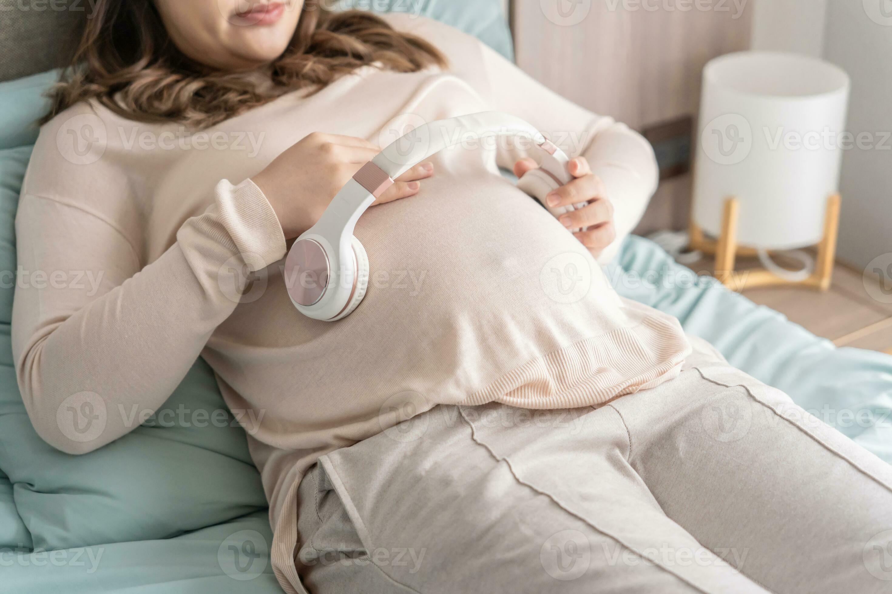 Pregnant asian woman holding headphone on belly playing music to her baby  in stomach relaxing pregnancy Mental health concept 33241683 Stock Photo at  Vecteezy