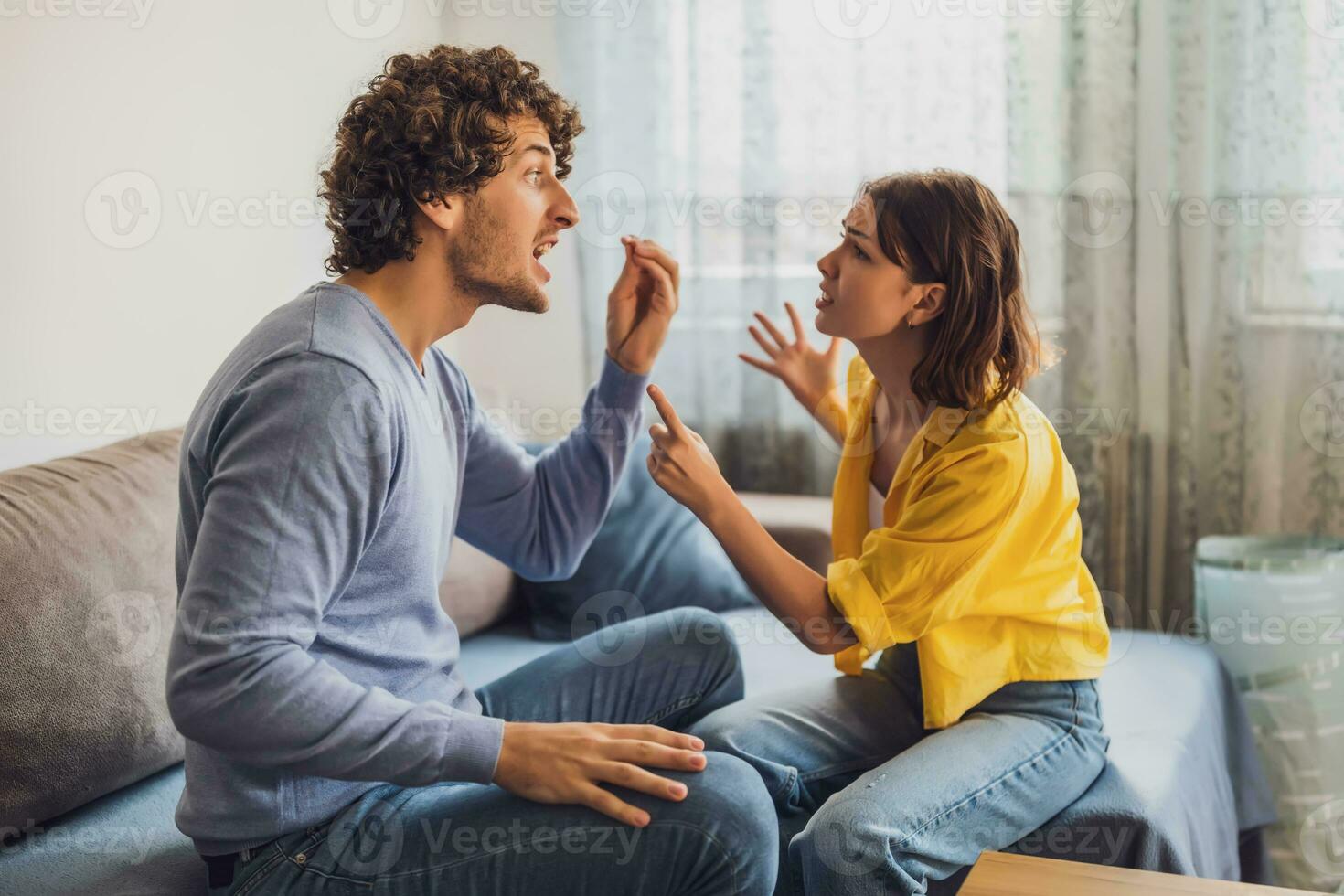 Man and woman are sitting at sofa and arguing. Relationship problems. photo