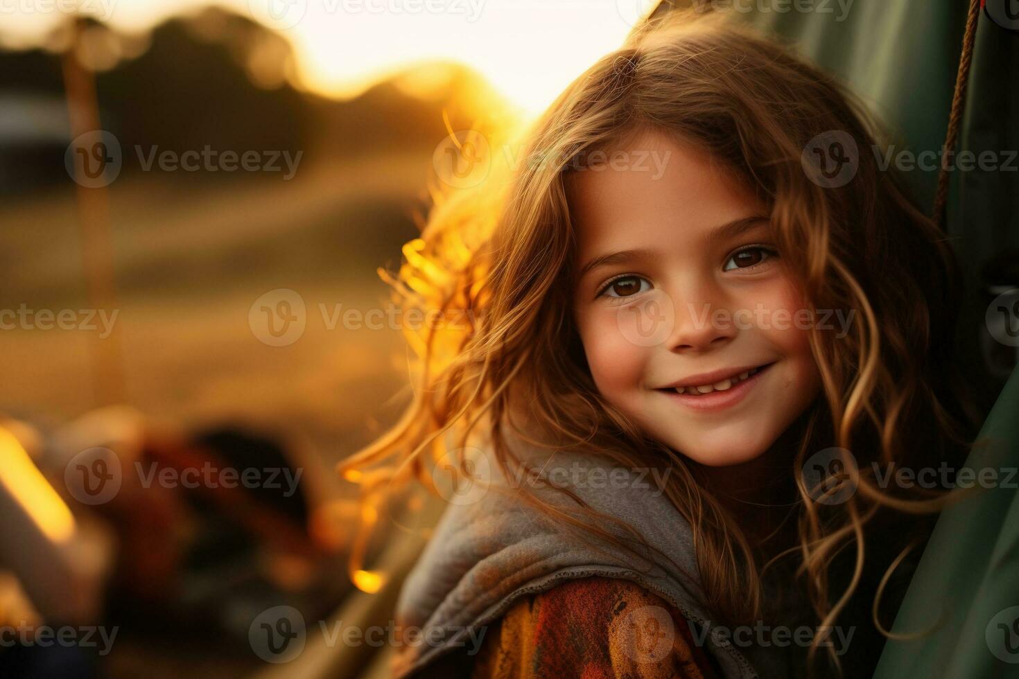 Portrait of cute little girl at camera while standing near camping tent at sunset AI generated photo