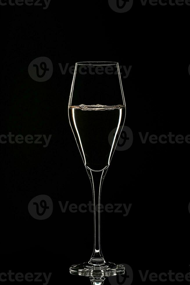 Backlit wine champagne glass with golden liquid photo