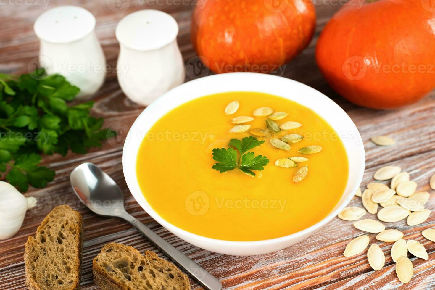 Vegetable cream pumpkin soup and rye bread for lunch. Preparing food from seasonal vegetables. Close-up. photo