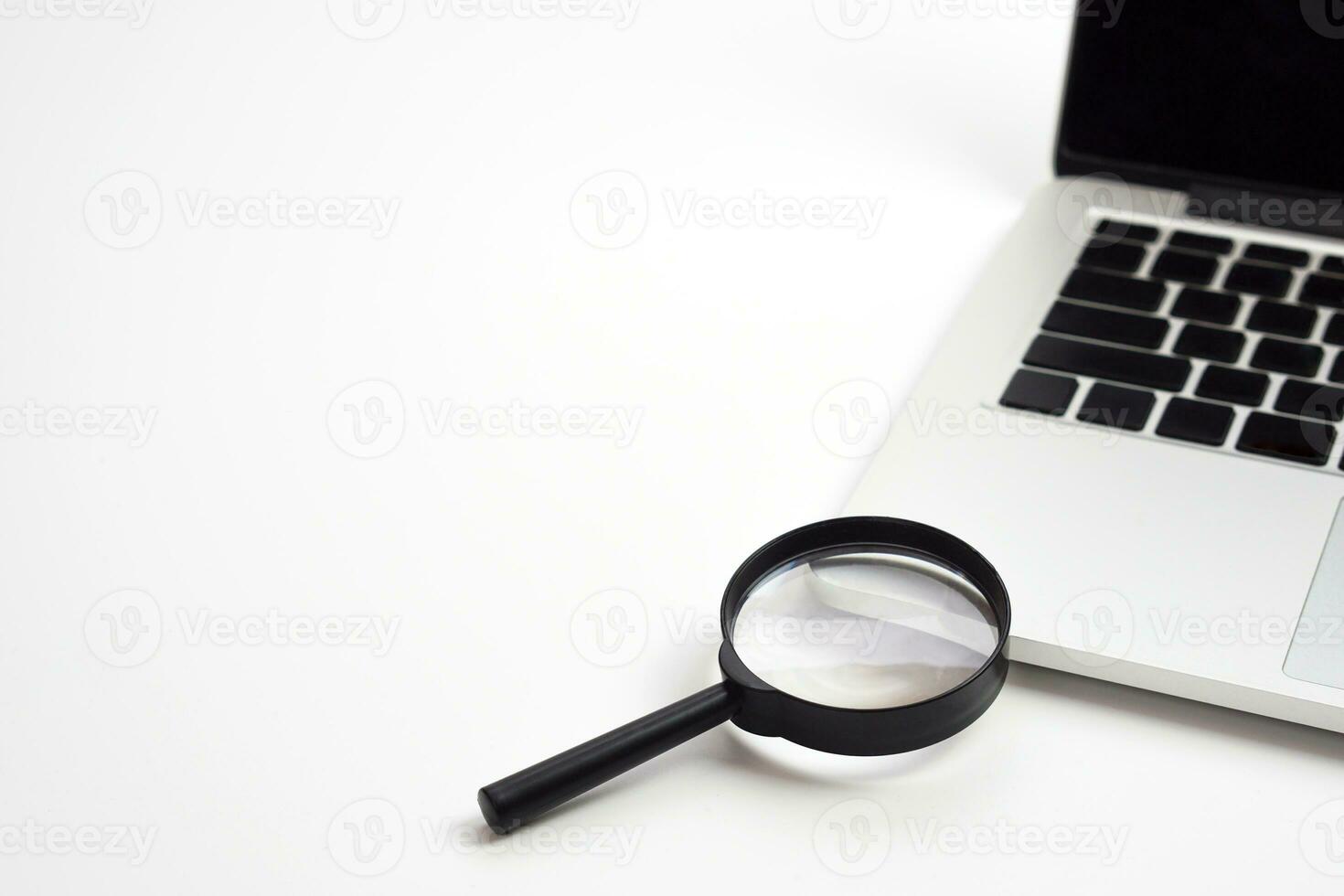 Laptop computer with magnifying glass. Work and search concept. photo