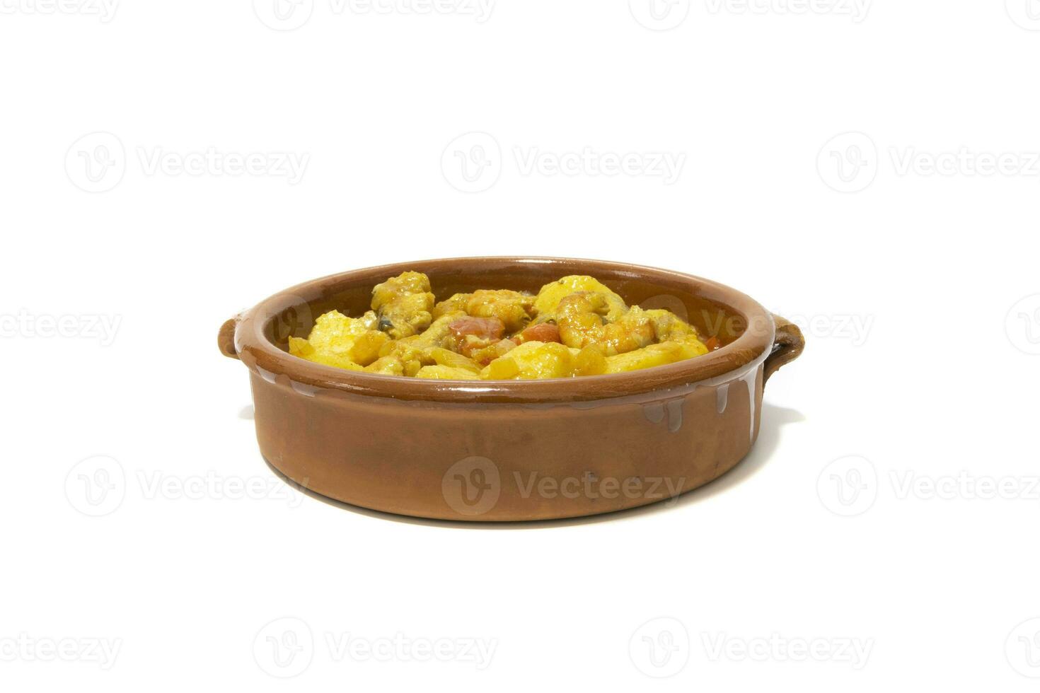 Potato stew with cod, served in a clay bowl. Isolated on white background. Spanish food concept. photo