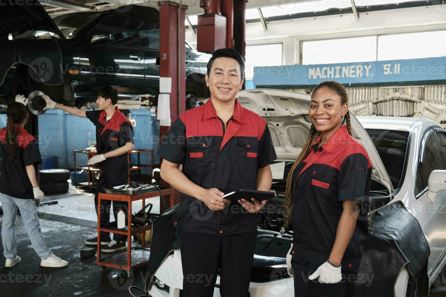 retrato de profesional mecánico supervisor socios Mira a cámara, trabajo a coche Servicio cochera, contento mantenimiento trabajos, cheque y reparar ingeniero ocupación en automotor industria negocio. foto