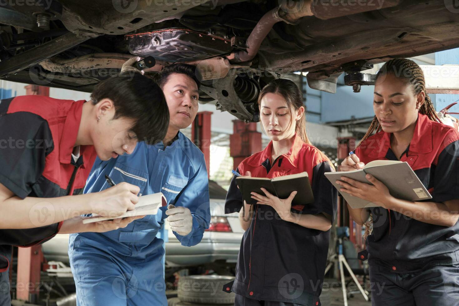 Specialist lecture, male supervisor engineer describe gasoline automotive fixing with mechanic worker staff teams for repair work at car service garage and maintenance jobs in automobile industry. photo