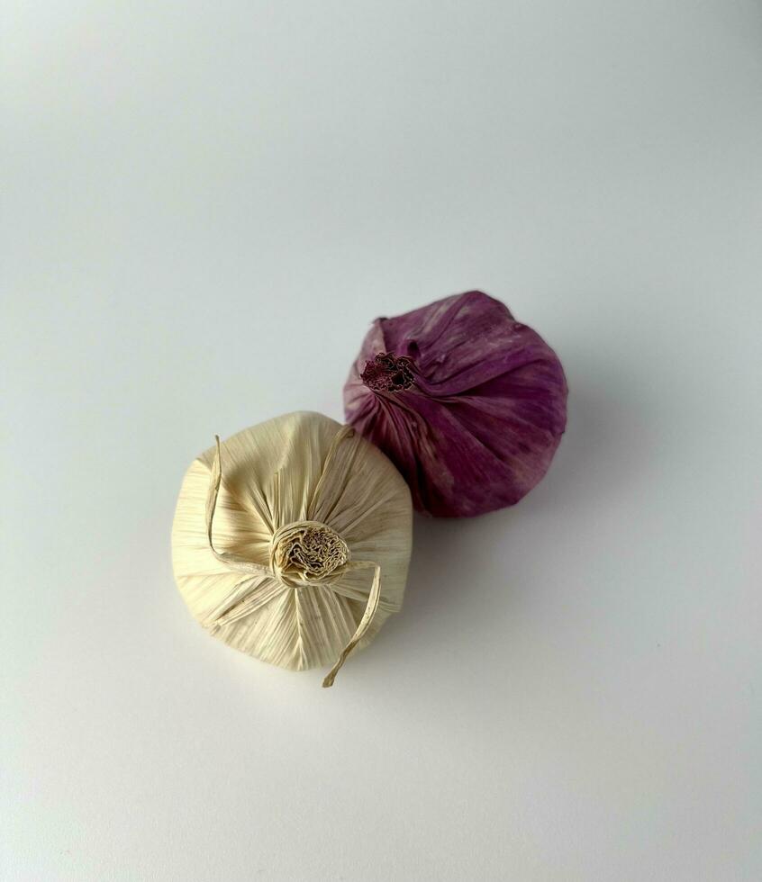 Artificial handcrafted white and red garlic. Photography property props object. Decorative object element isolated on plain white background. Cooking ingredients props. photo