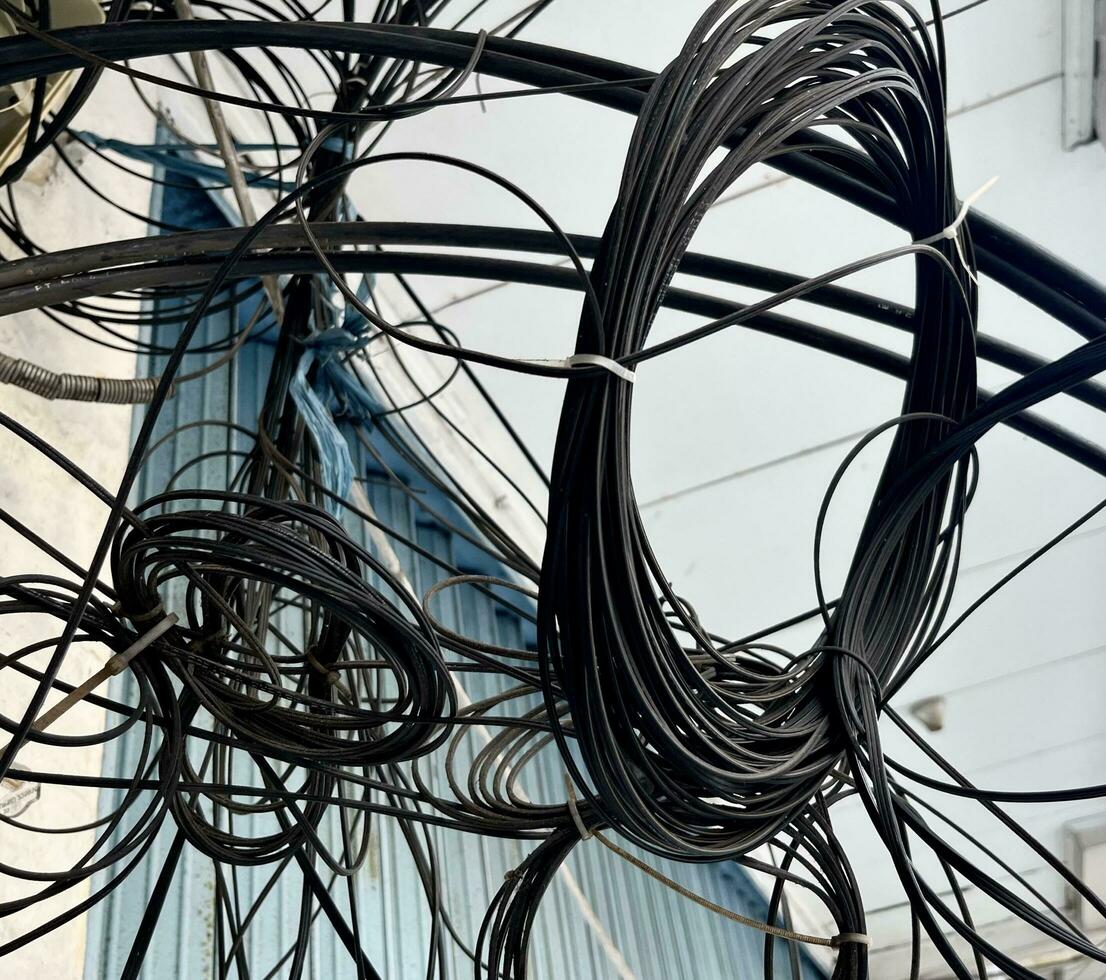 Messy electricity cable wires. Dangerous and untidy cable arrangements outdoor. photo