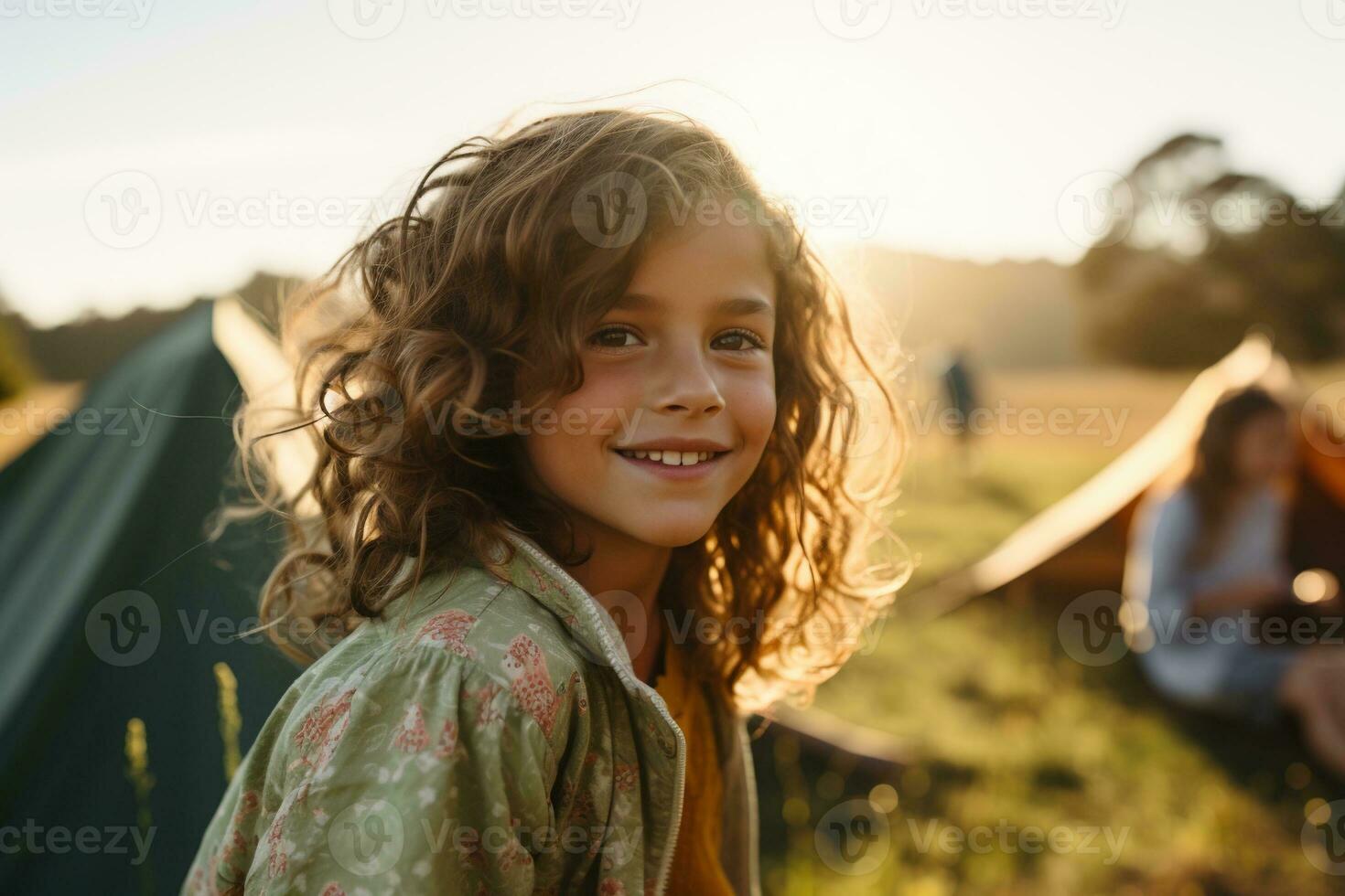 Portrait of cute little girl at camera while standing near camping tent at sunset AI generated photo