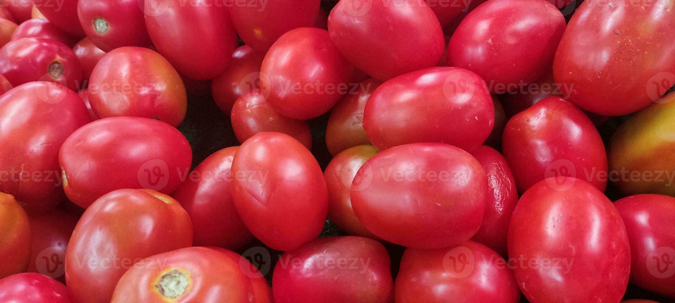 Tomatoes lying on a pile on top of each other, tomato texture. photo