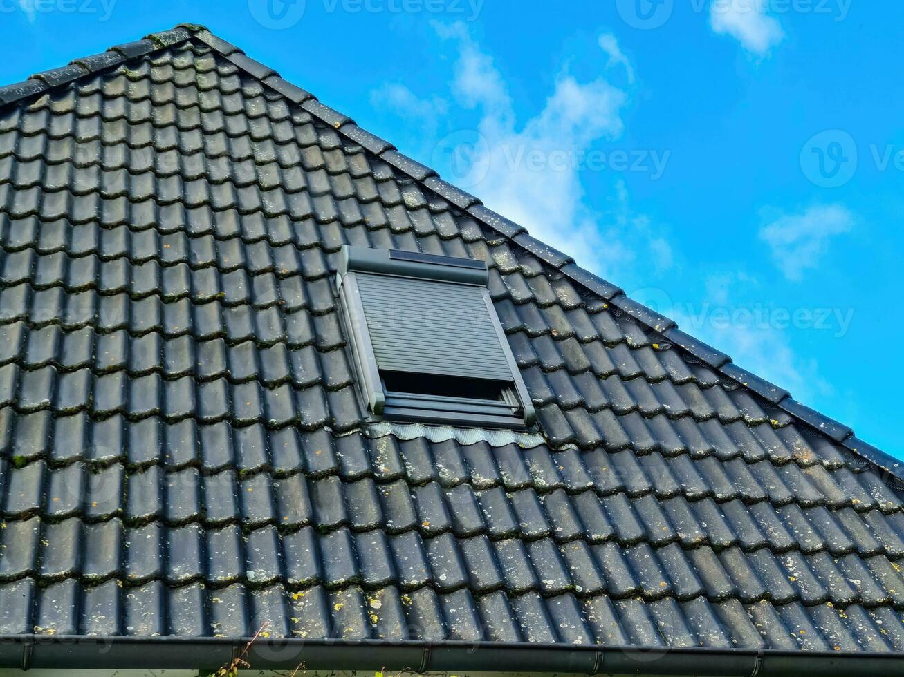 Open roof window in velux style with black roof tiles. photo
