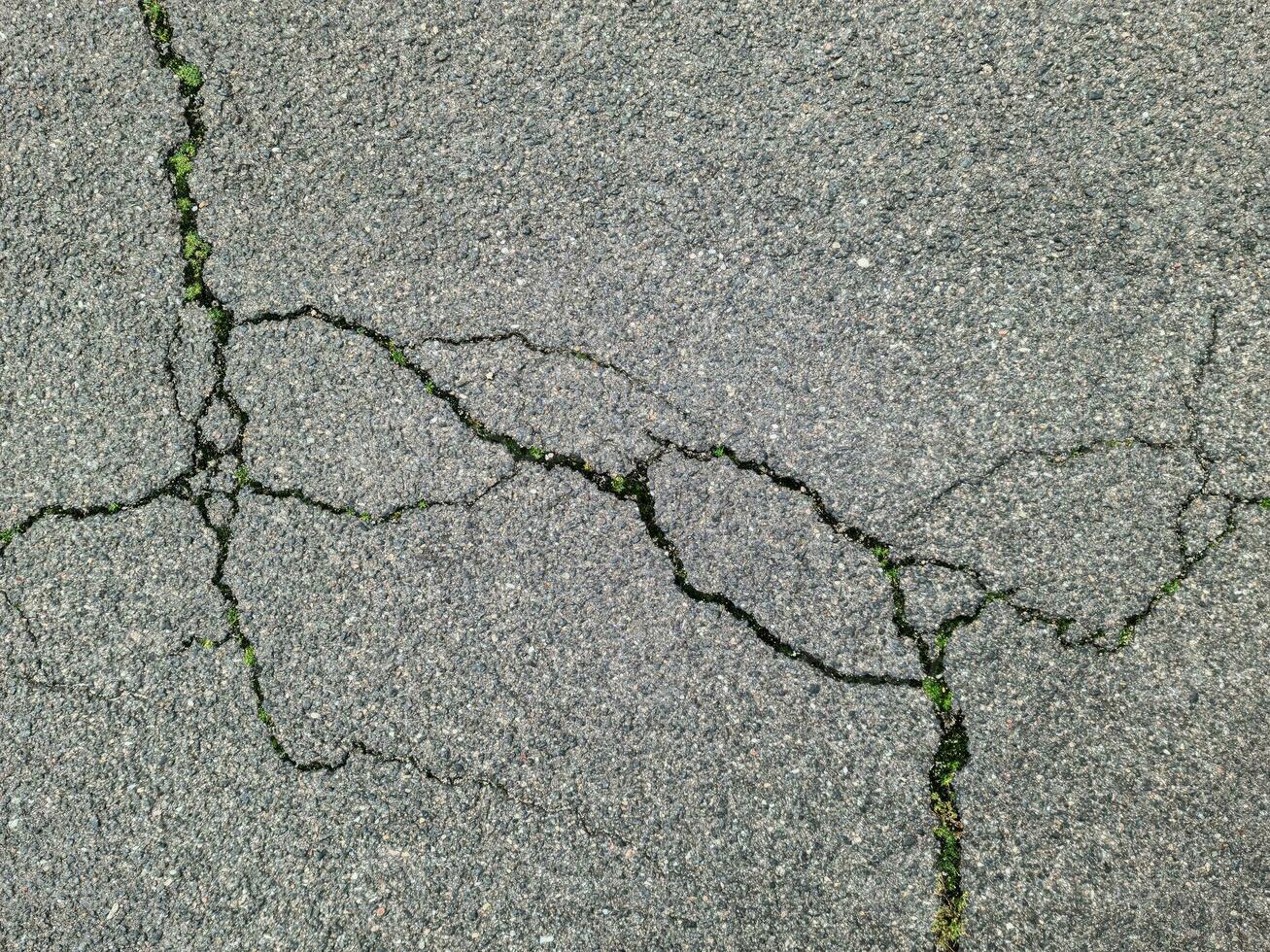 Asphalt surfaces of different streets and roads with cracks in close up photo
